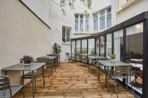 una fila di tavoli e sedie su un patio di Hôtel Beauquartier Montmartre a Parigi