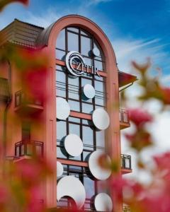 un bâtiment avec une horloge sur son côté dans l'établissement Hotel Zefir, à Drogobych