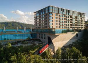 un edificio con un tren rojo delante de él en Bürgenstock Hotel & Alpine Spa, en Bürgenstock