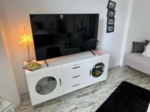 een wit entertainmentcentrum met een flatscreen-tv bij Ferienwohnung Roxana Stadtkern von Quedlinburg 55qm in Quedlinburg