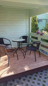 a patio with three chairs and a table on a porch at Guest house Rasa in Palanga