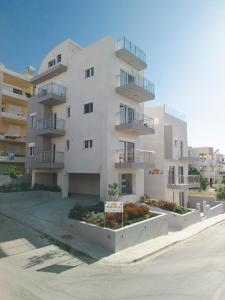 un edificio de apartamentos blanco con balcones en una calle en EDEL Luxury Apartments, en La Canea