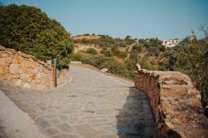 um caminho de pedra numa parede com árvores e edifícios em Villa Alba Sul Mare em Budoni