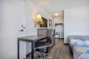 a hotel room with a desk and a bed at Motel 6 Jonesboro in Jonesboro