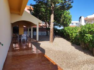 a patio of a house with a table and chairs at Beach House Villa At Peniche - Praia Consolação in Atouguia da Baleia