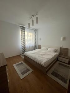 Habitación blanca con cama y ventana en MRM Aparthome, en Floreşti