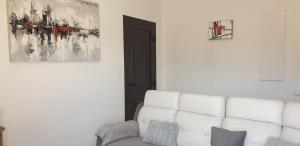 uma sala de estar com um sofá branco e um quadro em Très bel appartement,proche plage et centre ville. em Calvi