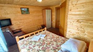 ein Schlafzimmer mit einem Bett in einer Holzhütte in der Unterkunft Казка Карпат in Drahobrat