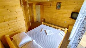 ein Schlafzimmer mit einem Bett in einer Holzhütte in der Unterkunft Казка Карпат in Drahobrat