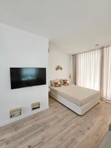 1 dormitorio con 1 cama y TV de pantalla plana en The Singular - Downtown Studio, en Faro