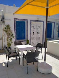 - une table et des chaises avec un parasol sur la terrasse dans l'établissement Dar Lilia Monastir, à Monastir