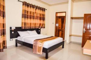 A bed or beds in a room at Ubuntu Palace Hotel Kampala