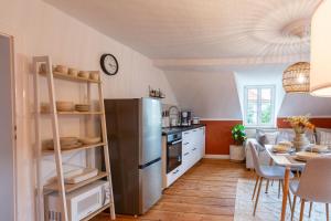 een keuken met een roestvrijstalen koelkast en een tafel bij Moderne Ferienwohnung mit Festungsblick im Zentrum in Königstein an der Elbe