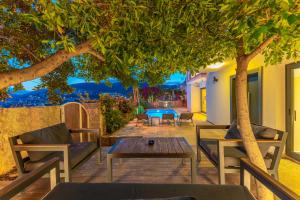 eine Terrasse mit einem Tisch und Stühlen unter einem Baum in der Unterkunft Luxus Villa Skyla mit 5 Schlafzimmern & Meer-Blick in Kaş