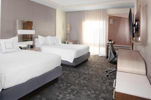 Courtyard by Marriott St. Louis West County في سانت لويس: غرفه فندقيه سريرين وتلفزيون