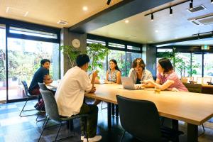 a group of people sitting at a table with a laptop at COGO TENNOJI in Osaka