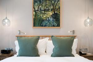 a bedroom with a bed with two green pillows at Lindeth Fell Country House in Bowness-on-Windermere