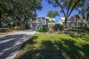 a house with a tree on the side of a road at Reel relaxing across from River in Huge 24 foot Swim Spa in Tampa