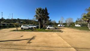 un grupo de autos estacionados en un estacionamiento en Cabañas Huallilemu Norte - Caja Los Andes, en El Quisco