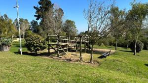 un parque con un banco y una mesa en el césped en Cabañas Huallilemu Norte - Caja Los Andes, en El Quisco