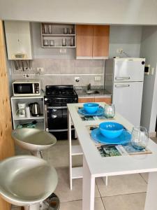 una cocina con una isla blanca con cuencos azules en 7-Exclusivo monoambiente en Moron centro, en Morón