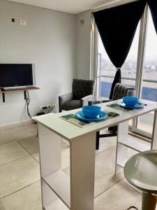 sala de estar con mesa blanca con sillas y TV en 7-Exclusivo monoambiente en Moron centro, en Morón