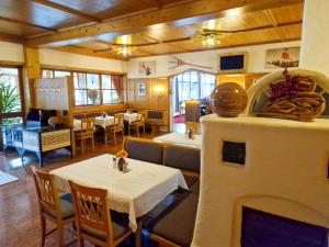 ein Restaurant mit einem Kamin, einem Tisch und Stühlen in der Unterkunft Das Alpin - Hotel Garni Guesthouse in Scheffau am Wilden Kaiser