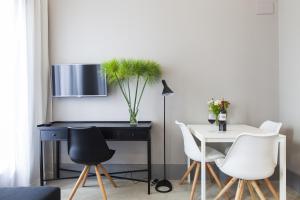 a dining room with a black desk and white chairs at Kare No Apartments by Sitges Group in Sitges