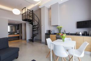 a kitchen and dining room with a white table and chairs at Kare No Apartments by Sitges Group in Sitges