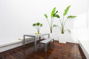 a table and a bench in a room with plants at Kare No Apartments by Sitges Group in Sitges