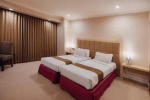 Katil atau katil-katil dalam bilik di Surabaya Suites Hotel Powered by Archipelago