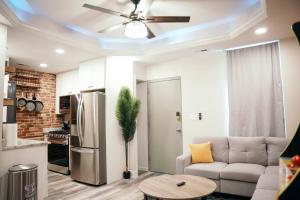 een woonkamer met een bank en een plafondventilator bij Sleek and Cozy Micro Fells Point Residence! in Baltimore