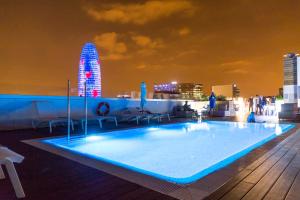 - une piscine sur le toit d'un bâtiment la nuit dans l'établissement Golden Hotel Barcelona, à Barcelone