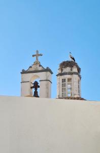 Una cruz sobre una pared junto a una iglesia. en The Singular - Downtown Studio, en Faro