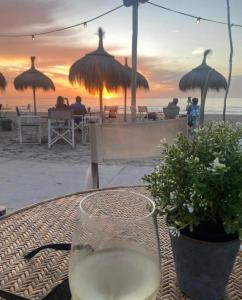 - un verre de vin assis sur une table sur la plage dans l'établissement Noordwijk BB228, à Noordwijk