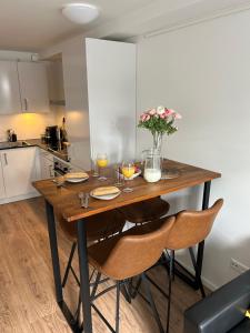 - une cuisine avec une table en bois, des chaises et des fleurs dans l'établissement Noordwijk BB228, à Noordwijk