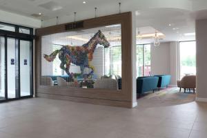 - une porte en verre avec un cheval dans le hall dans l'établissement Hampton By Hilton Hamilton Park, à Hamilton