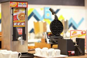 - une machine à café assise sur un comptoir avec des tasses de café dans l'établissement Hampton By Hilton Hamilton Park, à Hamilton