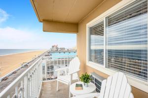 uma varanda com 2 cadeiras e vista para a praia em Dunes Suites Oceanfront em Ocean City