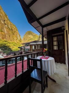 d'un balcon avec une table, des chaises et des montagnes. dans l'établissement Rupa Rupa High Jungle Eco B&B, à Machu Picchu