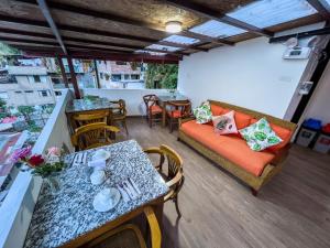 d'un balcon avec une table, des chaises et un canapé. dans l'établissement Rupa Rupa High Jungle Eco B&B, à Machu Picchu