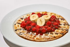 een pannenkoek met fruit en bananen op een witte plaat bij Hampton by Hilton Berlin City Centre Alexanderplatz in Berlijn