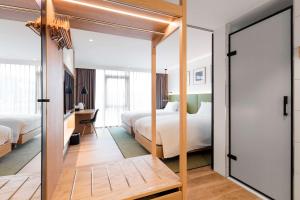 Habitación de hotel con 2 camas y espejo en Hilton Garden Inn Faroe Islands, en Tórshavn