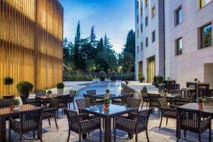 a patio at a hotel with tables and chairs at Hilton Podgorica Crna Gora in Podgorica