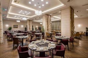 a restaurant with tables and chairs in a room at Hilton Podgorica Crna Gora in Podgorica