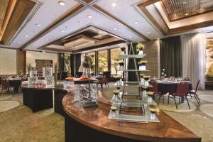 une salle à manger avec des tables, des chaises et une table centrale dans l'établissement DoubleTree by Hilton Durango, à Durango