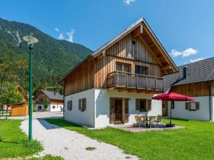 eine Scheune mit einem Tisch und einem roten Regenschirm in der Unterkunft Beautiful Chalet in Obertraun with Garden in Obertraun