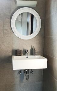 a bathroom with a white sink and a mirror at Studios Thea Fresh Rooms Thassos in Limenas