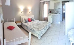 a small bedroom with two beds and a kitchen at Studios Thea Fresh Rooms Thassos in Limenas