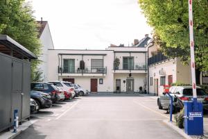 un parcheggio con auto parcheggiate di fronte a un edificio di B&B Pod vrbo a Lubiana